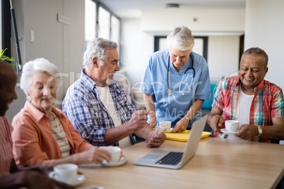 Healthcare worker serving coffee to senior people