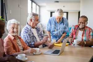 Healthcare worker serving coffee to senior people