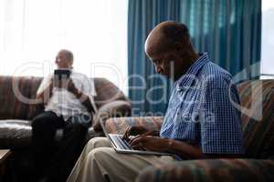 Senior man using laptop while sitting on sofa