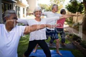 Smiling senior woman exercising with friends at park