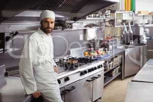 Portrait of smiling chef standing in commercial kitchen
