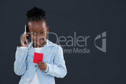 Portrait of businesswoman talking on phone while holding red card