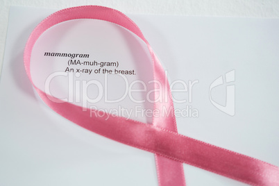 Close-up of pink Breast Cancer Awareness ribbon on paper with text