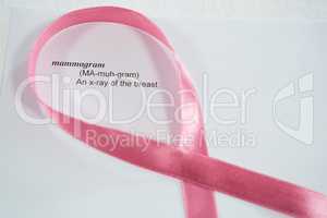 Close-up of pink Breast Cancer Awareness ribbon on paper with text