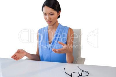 Businesswoman gesturing while sitting at table