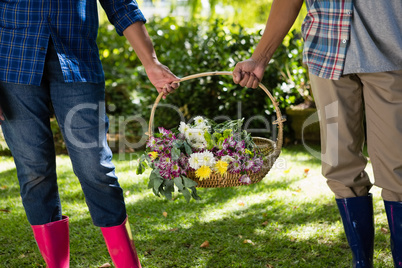 Senior couple walking in garden with flower basket