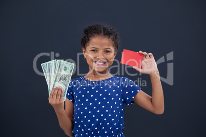 Portrait of girl showing credit card and currency