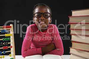 Cute girl with abacus and stack of books