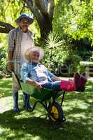 Senior man giving woman ride in wheelbarrow