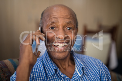 Portrait of cheerful senior man talking on mobile phone