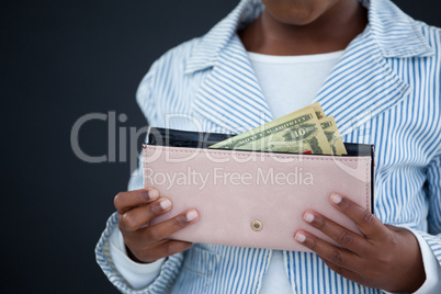 Midsection of businesswoman holding purse with paper currency