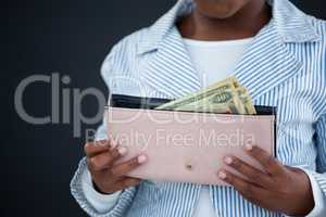 Midsection of businesswoman holding purse with paper currency