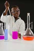 Schoolgirl doing a chemical experiment against black background