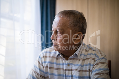 Thoughtful senior man by window
