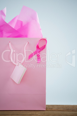 Close-up of pink spotted Breast Cancer Awareness ribbon on shopping bag