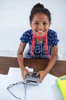 High angle view of smiling businesswoman using calculator