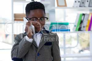 Confident businessman wearing eyeglasses talking on mobile phone