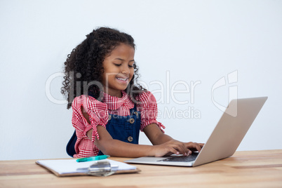 Smiling businesswoman using laptop computer at desk