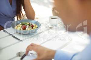 Woman having vegetable salad at restaurant