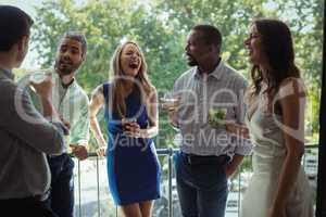 Group of friends interacting with each other while having cocktail drink