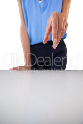 Businesswoman holding something while standing by table