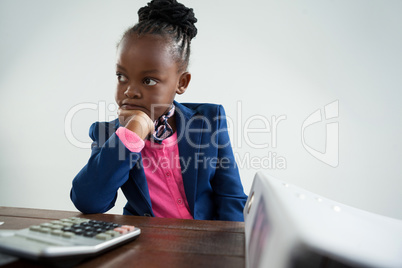 Thoughtful serious businesswoman looking at calculator