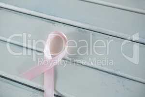 High angle view of pink Breast Cancer Awareness ribbon on white table