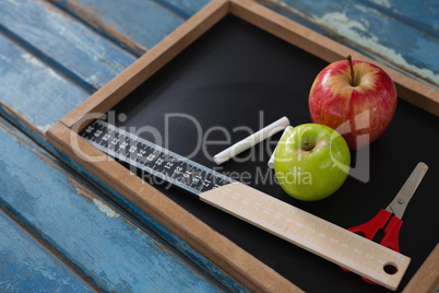 School supplies and slate on wooden table