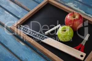 School supplies and slate on wooden table