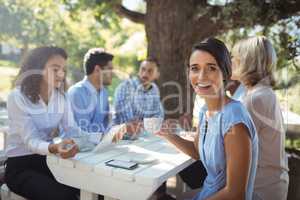 Woman sitting with friends in outdoor restaurant