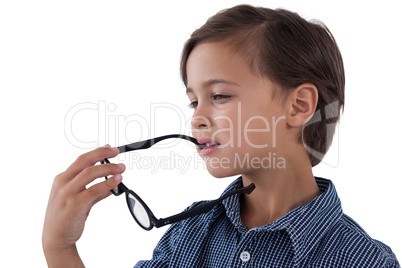 Thoughtful boy holding spectacles