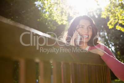 Woman sitting on bench and talking on mobile phone