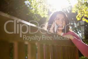 Woman sitting on bench and talking on mobile phone