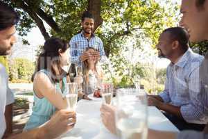 Group of friends celebrating womans birthday at outdoor restaurant