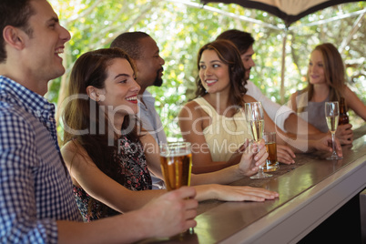 Friends interacting while having a alcohol at counter