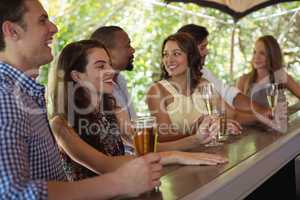 Friends interacting while having a alcohol at counter