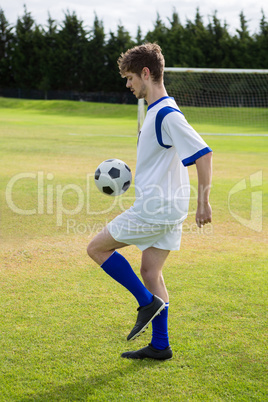 Side view of soccer player playing with ball