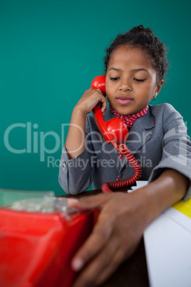 Girl pretending as businesswoman talking on land line phone