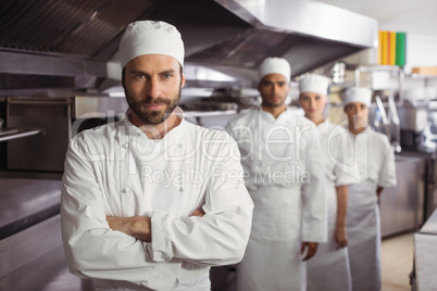 Happy chefs team standing together in commercial kitchen