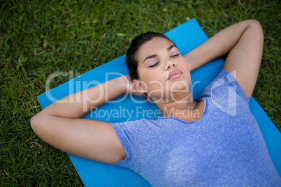 Young trainer relaxing on exercise mat