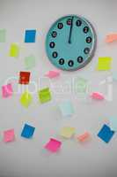 Adhesive notes with clock on wall