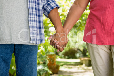 Mid-section of senior couple holding hands