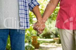 Mid-section of senior couple holding hands