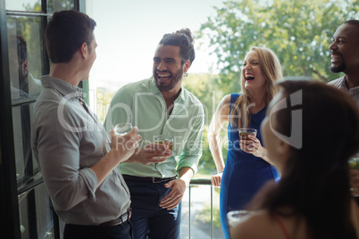 Group of friends interacting with each other while having cocktail drink