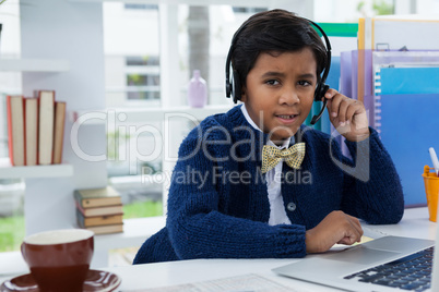 Businessman looking away while using headset