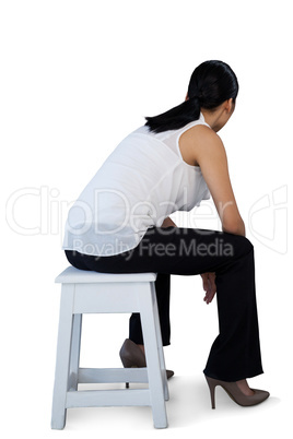 Full length of woman sitting on stool