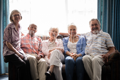 Portrait of smiling senior people sitting on couch