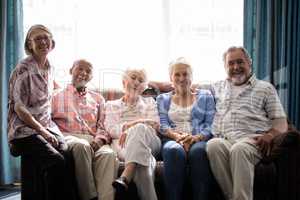 Portrait of smiling senior people sitting on couch