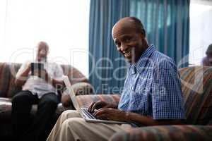 Portrait of senior man using laptop