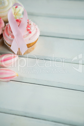 Close-up of Breast Cancer Awareness pink ribbons on cupcakes with tulips